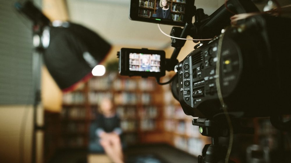 Video camera setup recording an interview in a library setting, representing video-based professional learning