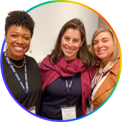 Three smiling K12 Coalition members at a conference, their arms over each other's shoulders.